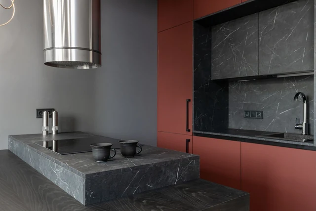 Burgundy kitchen ideas UK with deep red units and a dark stone worktop