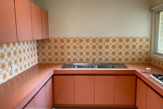 Terracotta kitchen ideas UK with warm earthy units and a patterned splashback