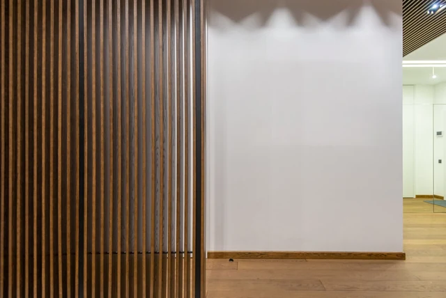 Slat wall ideas living room shown as a vertical wood slat wall